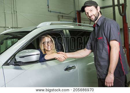 An auto mechanic and female customer in garage