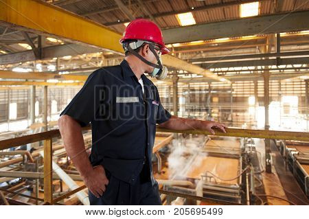 Padaeng industry Mae Sot Tak Thailand February20 2013 : Zinc mine. Back view of confident engineer looking at the factory mining and thinking.