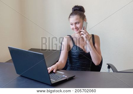 cute young office worker talking on cell phone in office.
