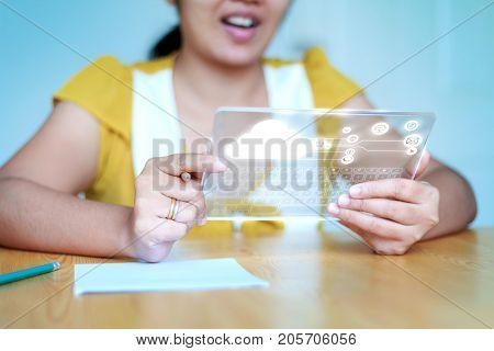 Close up shot Asian woman using clear tablet for futuristic cyber technology concept with clipping mask on tablet shallow depth of field