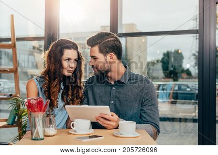 Couple Using Tablet In Cafe