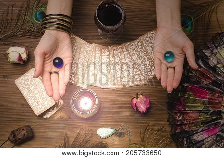 Fortune teller female hands and tarot cards on wooden table. Divination concept.