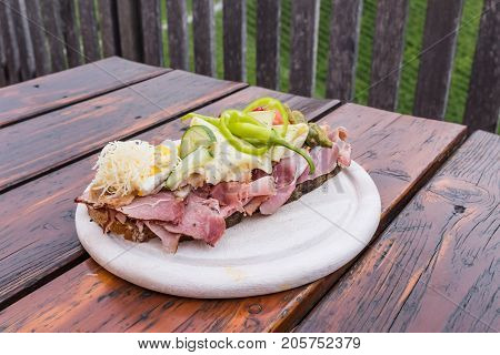 Traditional bread with lots of cold cuts on wooden table on south Styrian vine route in Austria