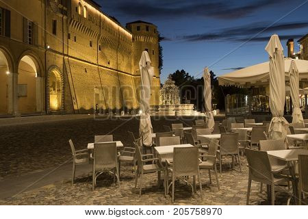Cesena (Emilia Romagna Italy): the medieval castle in the main square of the city at evening with tables and chairs in foreground