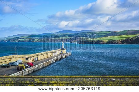 A pier in the sea surrounded by beautiful Isle of Man landscape