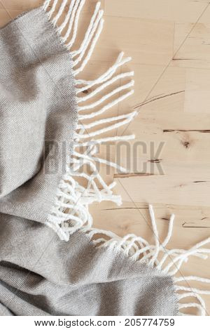 warm wool throw plaid on wooden background