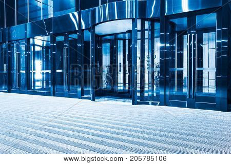modern entrance with revolving door,blue toned.