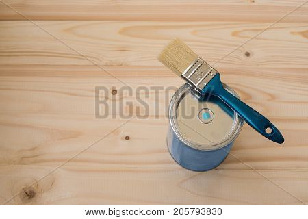 Blue paint and brush on wooden background, top view. Home improvement paint brush and opened can of blue paint. Bank blue paints and brush on a wooden background. brush and paint on a wooden background.