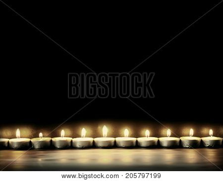Burning Small Wax Candles On Dark Background.