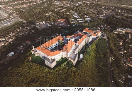 Beautiful panoramic view from the air to Palanok Castle at sunset and the city of Mukacheve