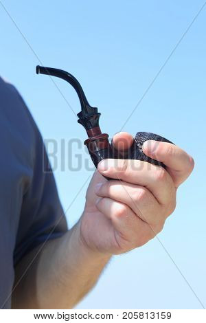man smokes a handmade tube of cherry wood
