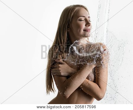 Pretty nude blonde with her hair loose enjoying water splash isolated cropped shot