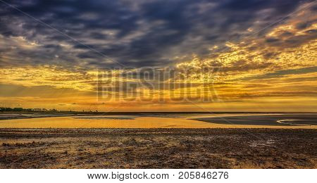 Beutiful colorful sunset at the Couesnon river estuary near the Mont Saint Michel Abbey.