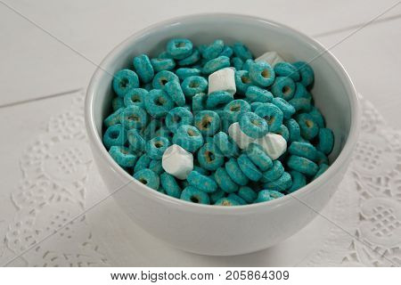 Bowl of froot loops and marshmallow on lace doily