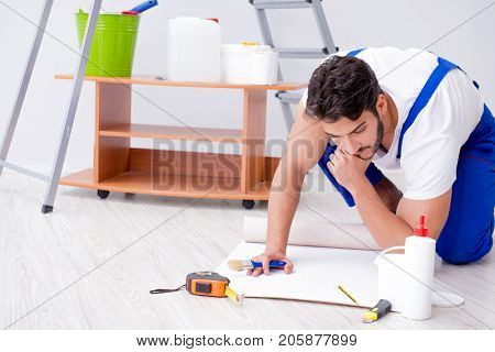 Repairman doing renovation repair in the house with paper wallpa