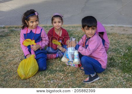 Fars Province Shiraz Iran - 19 april 2017: Preschool children are sitting on the lawn grass in the park.