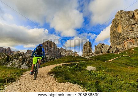 Cycling,View of cyclist riding mountain bike on single trail in Dolomites, Cinque Torri, South Tirol, Italy