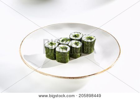 Maki rolls with seaweed with Hiashi wakame served on white flat plate. Asian menu for gourmets in luxury restaurant