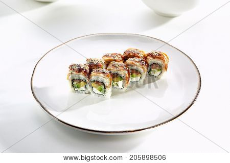 Kanada sushi rolls with salmon, eel, Philadelphia cheese, avocado and cucumber served on white flat plate. Asian menu for gourmets in luxury restaurant