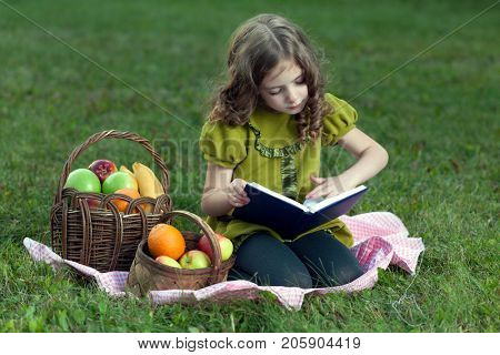beauty girl with fruit read book in summre park.