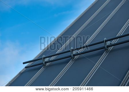 Standing seam metal roof close up with snow guards and blue sky in the background
