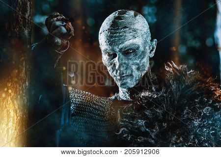 Zombie warrior in knightly armor stands in the night forest. Fantasy horror film. Halloween.