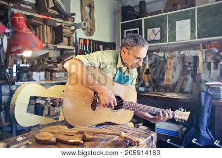 Lutist trying a hand crafted guitar
