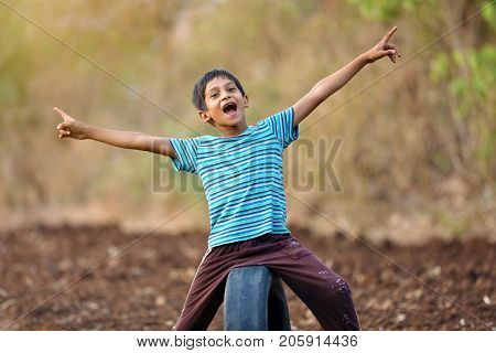 cute indian poor child playing cricket  at village