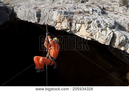 Speleologist ascending by a rope. Zaragoza Province, Aragon, Spain.