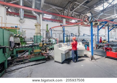 worker behind the dashboard in the workshop for the production of aluminum profiles. aluminum extrusion press