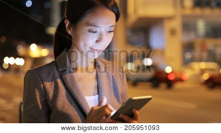 Business woman use of mobile phone and waiting for taxi
