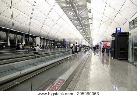 Hong Kong, China: April, 2017: Passengers traveling on the moving walkway at the International Airport in Hong Kong. It is located on the island of Chek Lap Kok.