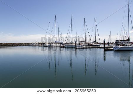 t Kilda, Australia: March 09, 2017: Yachts moored in the calm blue waters in marina off the iconic St Kilda Pier.
