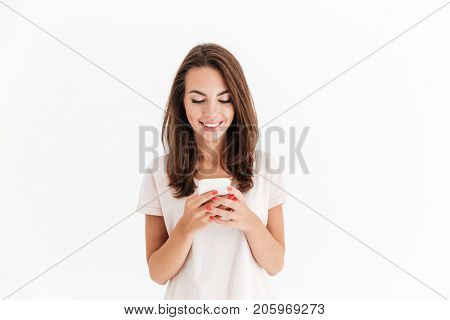 Happy brunette woman writing message on her smartphone over white background