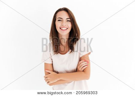 Laighing woman with crossed arms looking at the camera over white background