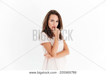 Angry pensive woman looking at the camera over white background