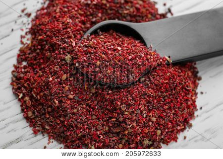 Maqui berry powder and measuring spoon on wooden background