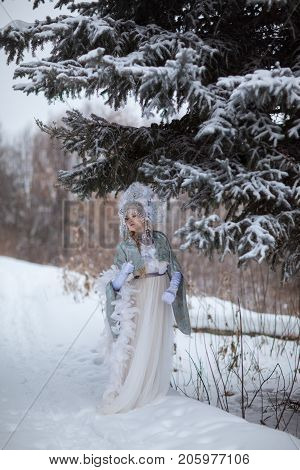woman in a Snow Maiden costume in a winter forest