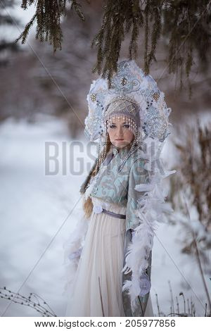 woman in a Snow Maiden costume in a winter forest