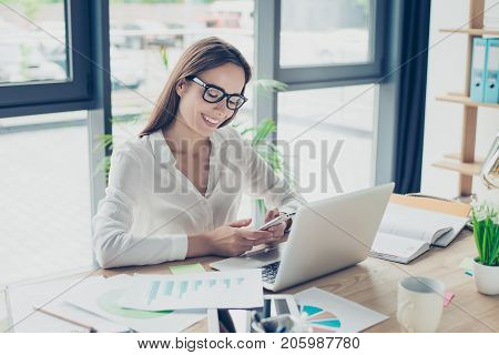 Comfort And Cozy Place. Young Cute Lawyer In Black Trendy Eyewear Is Browsing On Her Phone, Sitting
