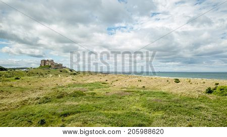 An elevated drone view of Bamburgh Castle on the coast of the north of England surrounded by natural heathland.