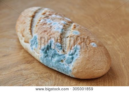 Moldy Bread On A Wooden Background. Improper Storage Of Food.