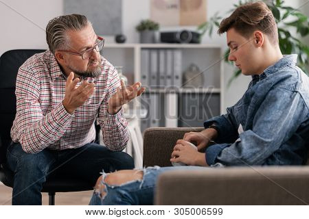 Senior Account Manager And Young Man During Job Interview In Small Firm