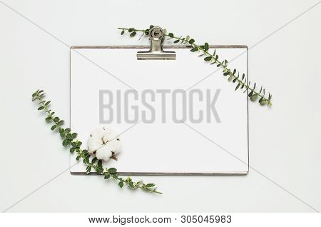 Blank White Paper With Folder And Metal Clothespin, Spring Green Twigs Of Plants On Gray Background