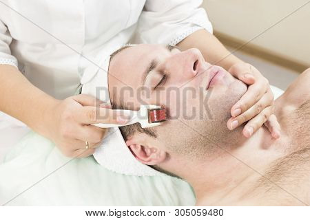 Young Man On The Procedure Of Rejuvenation And Cleansing Of The Skin Of The Modern Medical Instrumen