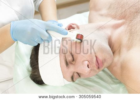 Young Man On The Procedure Of Rejuvenation And Cleansing Of The Skin Of The Modern Medical Instrumen