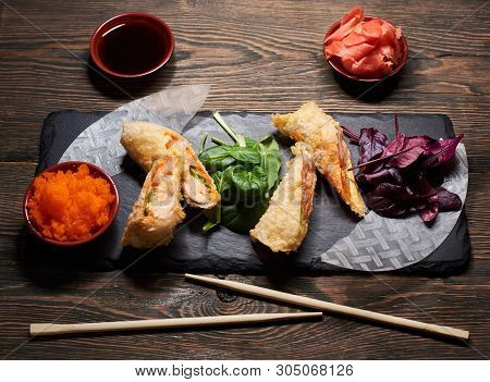 Top View Of Japanese Tempura Dish Serving With Green, Red Basil, Rice Paper On Stone Plate. Sauces, 