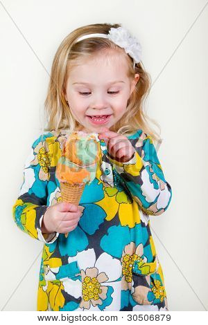 lille blond pige ser på is kegle.