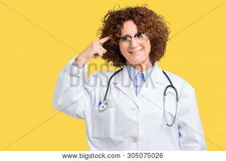 Middle ager senior doctor woman over isolated background Smiling pointing to head with one finger, great idea or thought, good memory