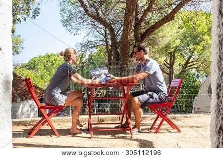 Couple In Front Of Mobile Home House At Camping Siteon Resting And Planing Vacation Day Trips. Famil